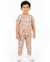 Child wearing a beige pajama set with animal prints on a white background